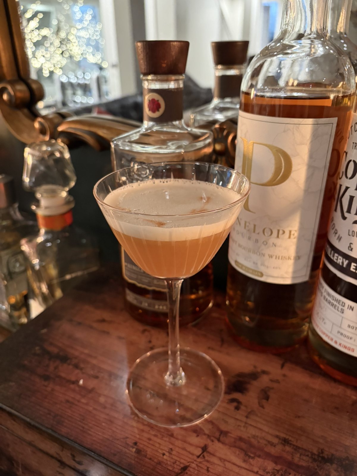 Craft whiskey sour cocktail with foam and citrus twist, mixed to order