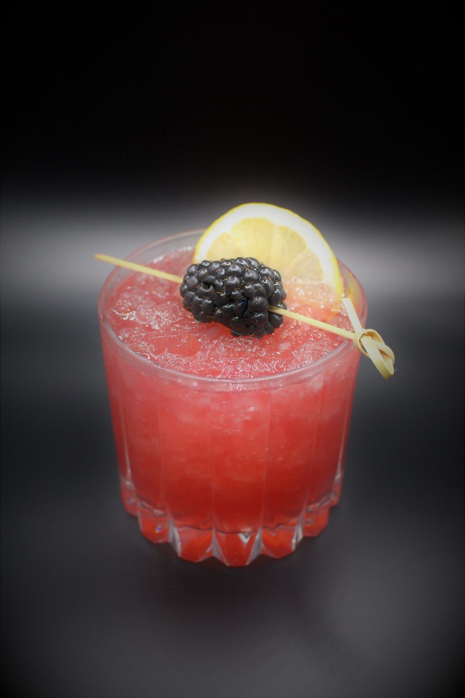 Craft cocktail garnished with a blackberry