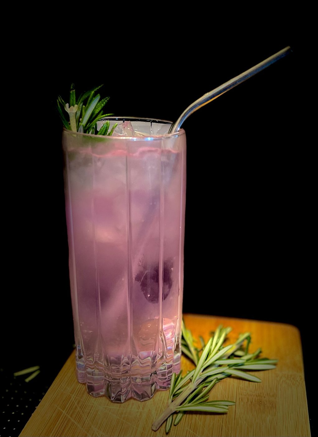 Herb-garnished cocktail with a rosemary sprig