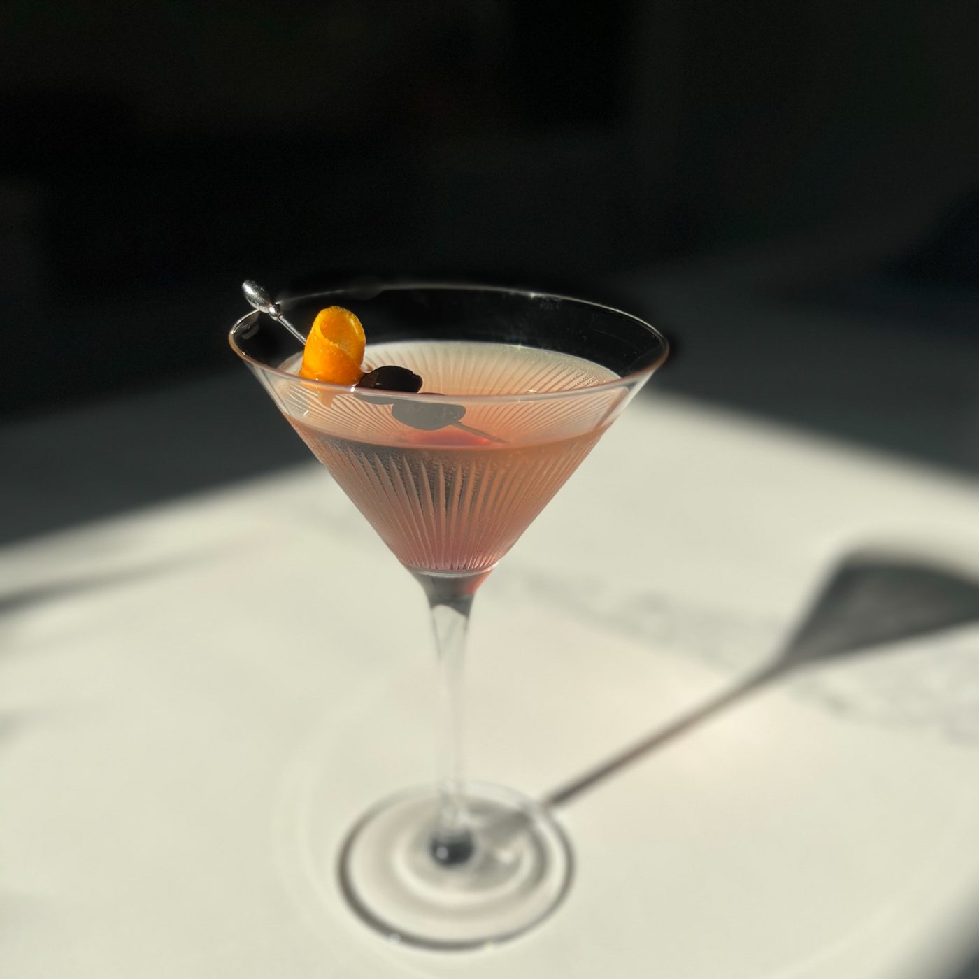 Signature cocktail with an orange twist, natural light