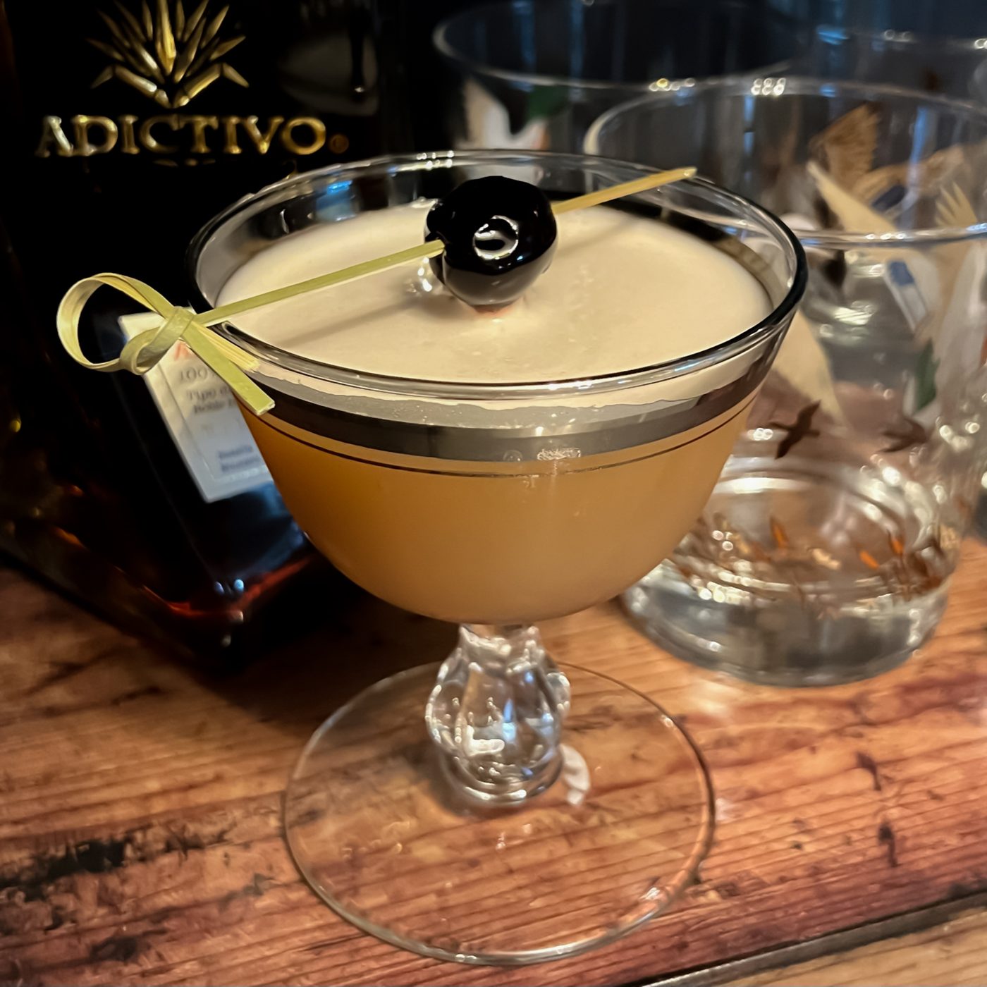 Signature cocktail with a cherry garnish, bottle service styling