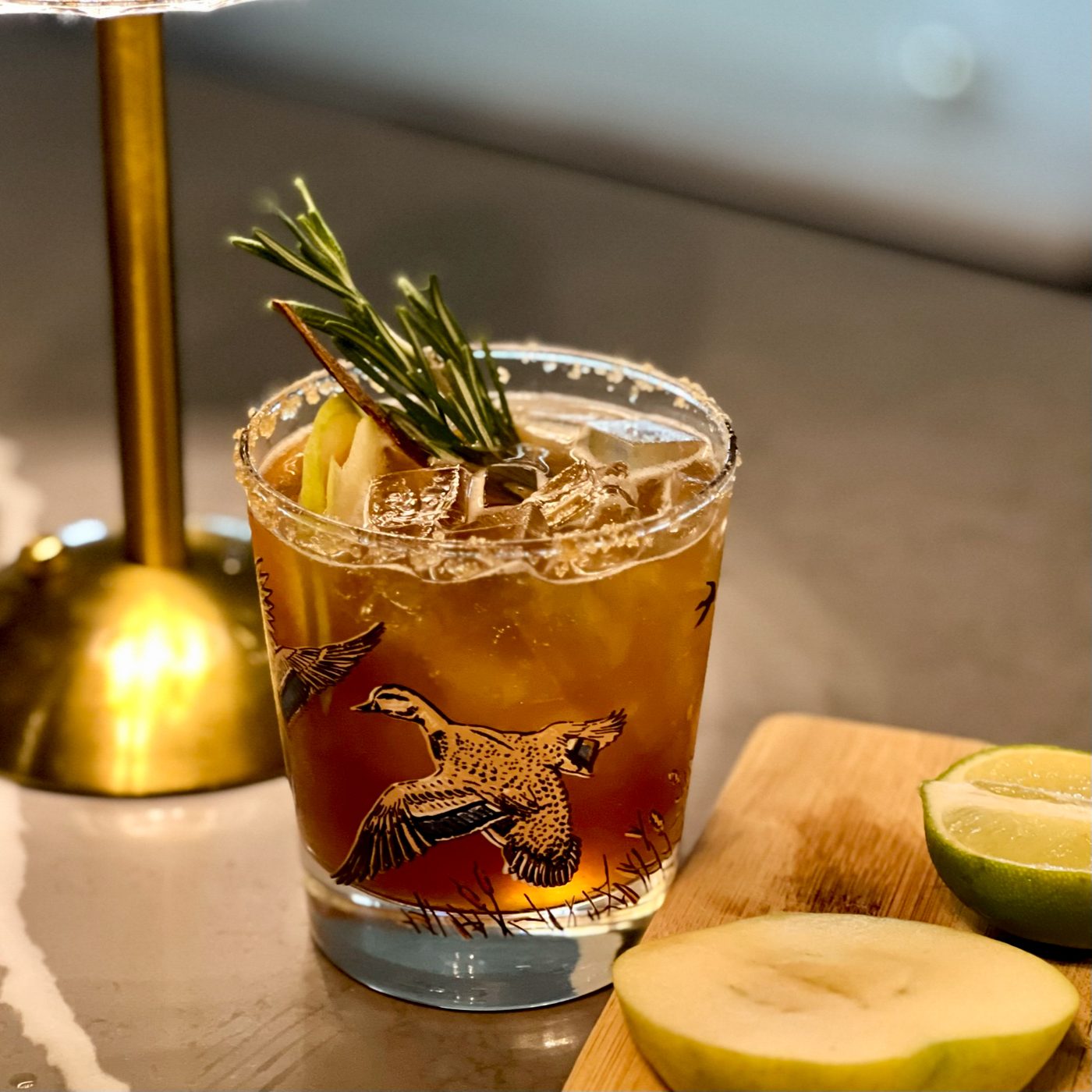 Old fashioned cocktail with rosemary and citrus garnish