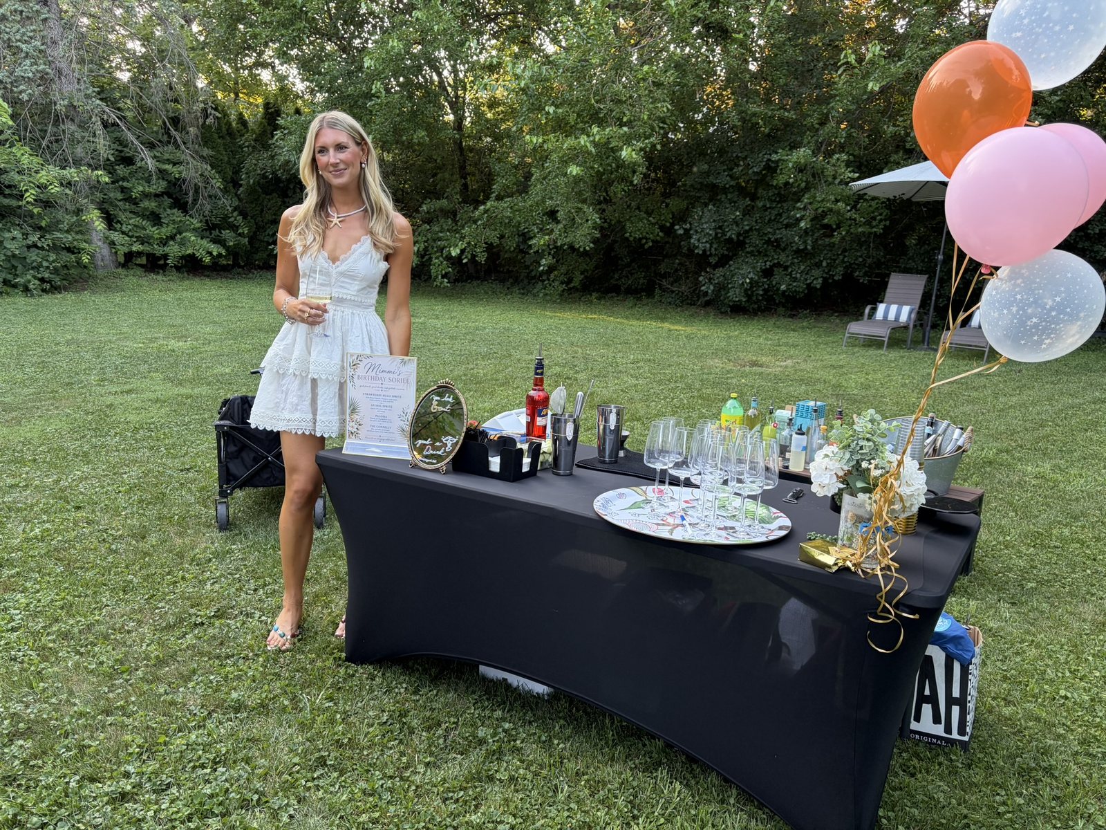 Guest celebrating a birthday soiree next to the Legend Mobile Bar setup, string lights and balloons