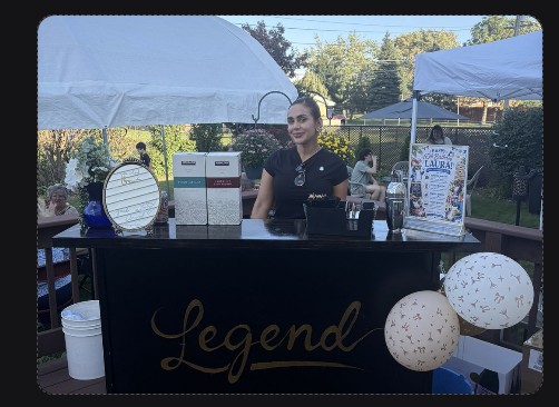 Legend Mobile Bar branded cart set up under tents at an outdoor private party, personalized sign and balloons
